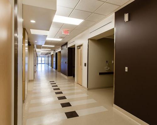 Interior photo of a corridor at the California Proton Cancer Therapy Center. Brown and white walls line the hallway.